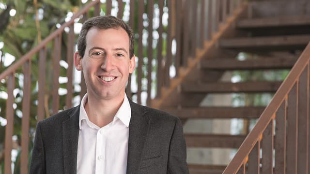 Mann im Anzug steht auf einer Treppe Mann im Anzug steht auf einer Treppe