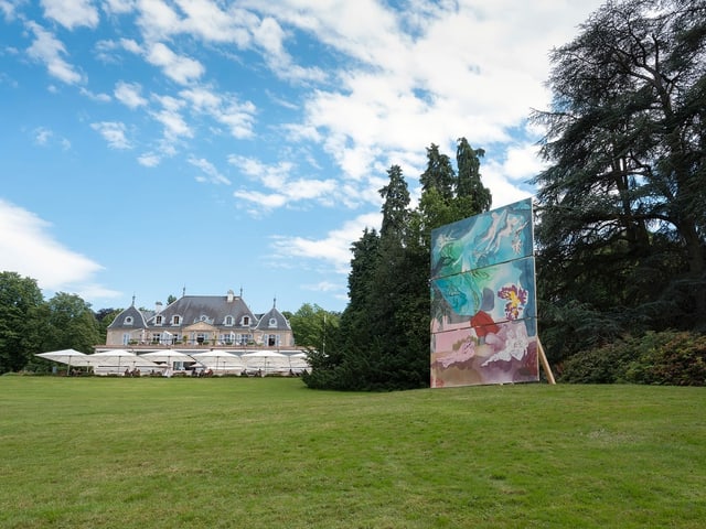 Eine riesige bemalte Leinwand steht in einem Park. Eine riesige bemalte Leinwand steht in einem Park.