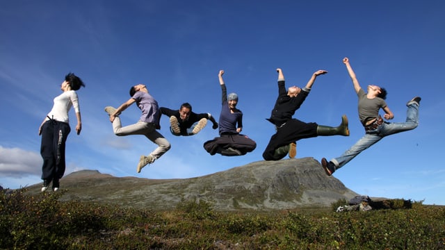 Sechs Tänzerinnen und Tänzer springen in freier Natur in einer markanten Pose in die Luft. Sechs Tänzerinnen und Tänzer springen in freier Natur in einer markanten Pose in die Luft.