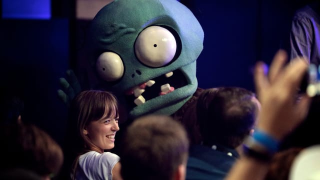 Ein Zombie aus «Plants vs. Zombies» versucht, eine Frau zu erschrecken. Sie lacht.