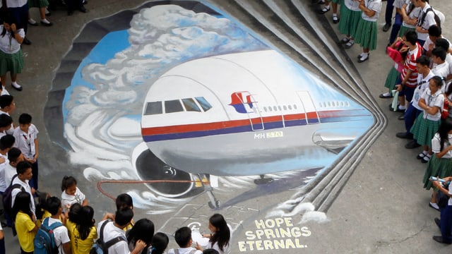Kinder stehen um ein gemaltes Flugzeug. Kinder stehen um ein gemaltes Flugzeug.
