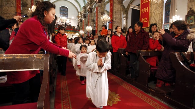 Kleine Kinder als Engel verkleidet laufen den Gang einer Kirche hinunter. Kleine Kinder als Engel verkleidet laufen den Gang einer Kirche hinunter.