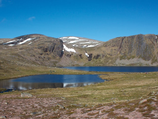 Zwei Bergseen, im Hintergrund nicht sehr hohe, aber felsige Berge mit Schneefeldern. Zwei Bergseen, im Hintergrund nicht sehr hohe, aber felsige Berge mit Schneefeldern.