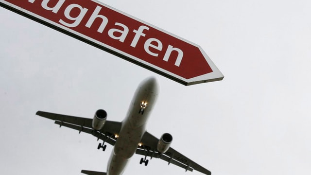 Ein Flugzeug und ein Wegweiser mit der Aufschrift Flughafen. Ein Flugzeug und ein Wegweiser mit der Aufschrift Flughafen.