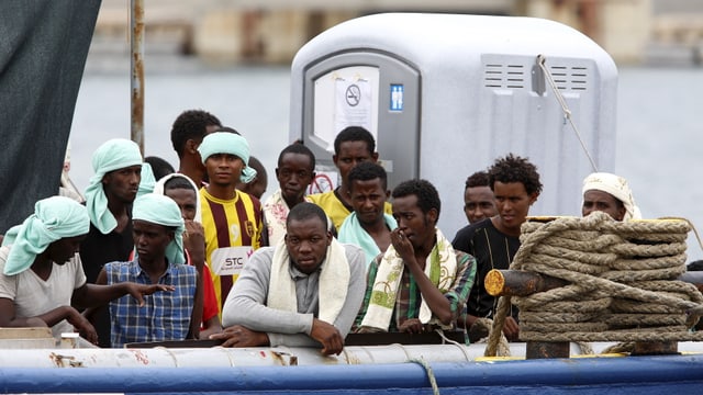 Ein gutes Dutzend Männer stehen auf einem Boot Ein gutes Dutzend Männer stehen auf einem Boot