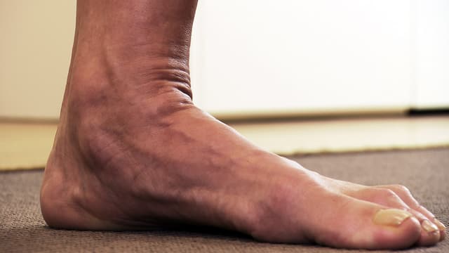 Seitliche Aufnahme eines nackten Fusses auf einem Teppich Seitliche Aufnahme eines nackten Fusses auf einem Teppich