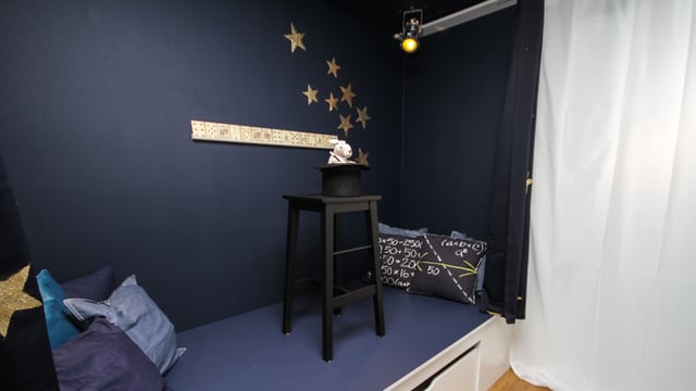 Die Vorhänge vor dem Bett bieten Rückzug. Vor der Bühne geben goldene Sterne den Vorhängen Zauberglamour Die Vorhänge vor dem Bett bieten Rückzug. Vor der Bühne geben goldene Sterne den Vorhängen Zauberglamour