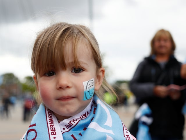 Mädchen mit Manchester-City-Aufkleber im Gesicht