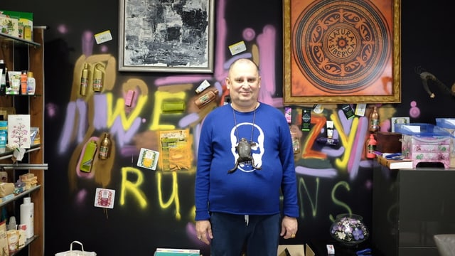 Trubnikow in seinem Büro. Die Wand hinter ihm ist besprayt, es hängen Bilder. Man kann den gelben Schriftzug "We crazy Russians" erkennen. Trubnikow in seinem Büro. Die Wand hinter ihm ist besprayt, es hängen Bilder. Man kann den gelben Schriftzug "We crazy Russians" erkennen.