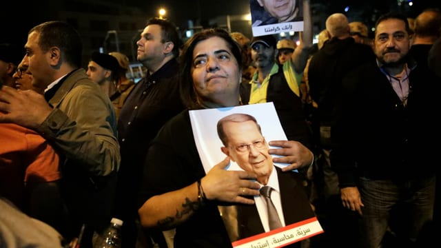Frau hält Bild umarmt. Darauf ist Aoun zu sehen. Frau hält Bild umarmt. Darauf ist Aoun zu sehen.