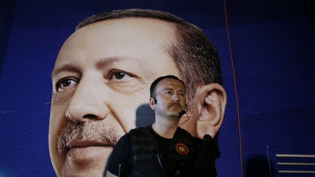 Sicherheitsbeamter vor einem Poster von Erdogan Sicherheitsbeamter vor einem Poster von Erdogan