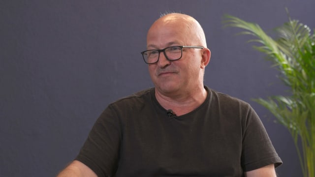Ein Mann mit Glatze und T-Shirt in einer Interview-Situation. Ein Mann mit Glatze und T-Shirt in einer Interview-Situation.
