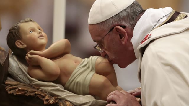 Papst Franziskus küsst das Jesuskind. 
