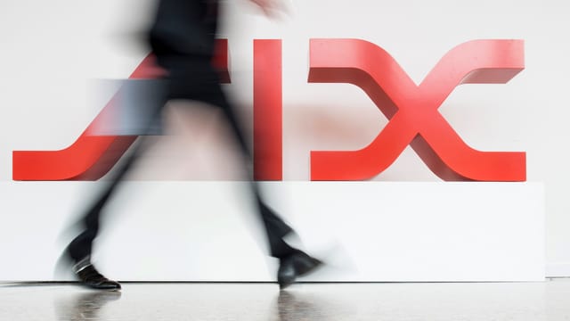 Eine Person geht an einem SIX-Logo vorbei. Eine Person geht an einem SIX-Logo vorbei.