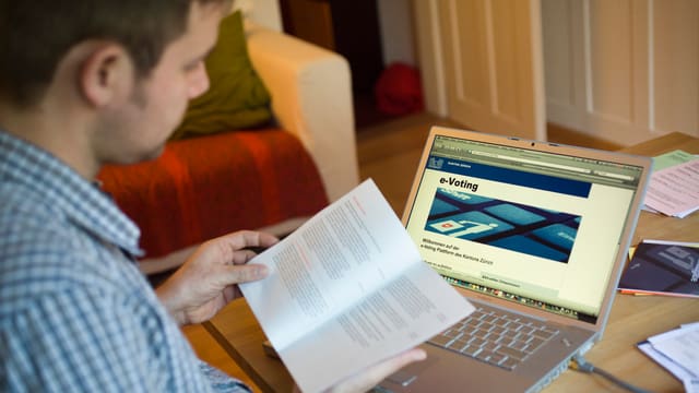 Mann mit Wahlzettel vor dem Computer. Mann mit Wahlzettel vor dem Computer.