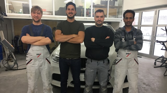 Antonio Tesfaghabir aus Eritrea (rechts) mit Team in der Autowerkstatt. Antonio Tesfaghabir aus Eritrea (rechts) mit Team in der Autowerkstatt.