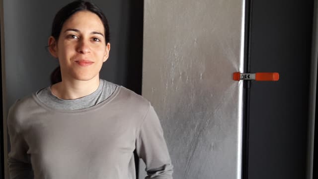 Eine junge Frau steht vor einem grauen Hintergrund. Eine junge Frau steht vor einem grauen Hintergrund.