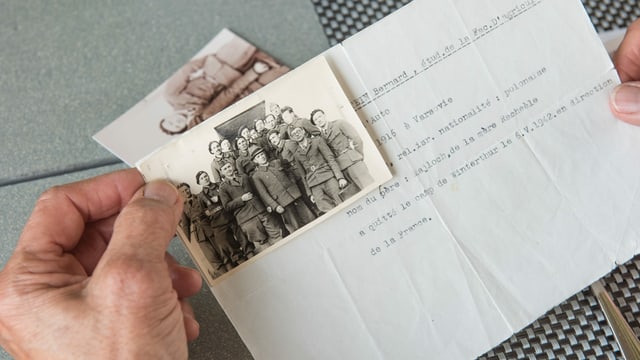 Hände, die ein altes Papier und ein schwarz-weiss Foto halten Hände, die ein altes Papier und ein schwarz-weiss Foto halten