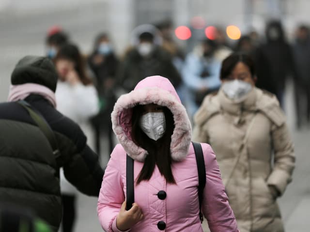 Menschen in Peking mit Mundschutz. Menschen in Peking mit Mundschutz.