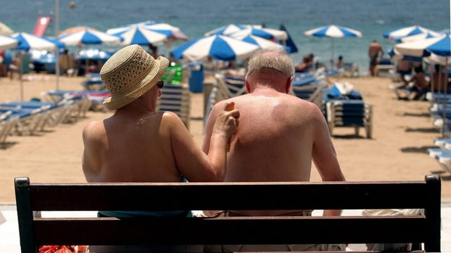 Eine Seniorin tippt mit dem Finger auf die Haut ihres Ehemanns, um einen Fleck zu zeigen. Eine Seniorin tippt mit dem Finger auf die Haut ihres Ehemanns, um einen Fleck zu zeigen.