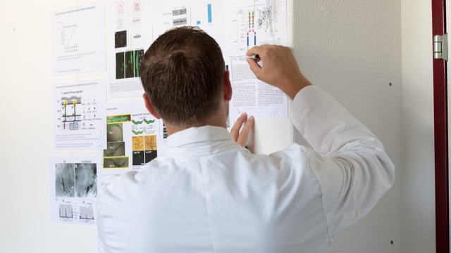 Collin Ewald an einer Wand mit wissenschaftlichen Grafiken Collin Ewald an einer Wand mit wissenschaftlichen Grafiken