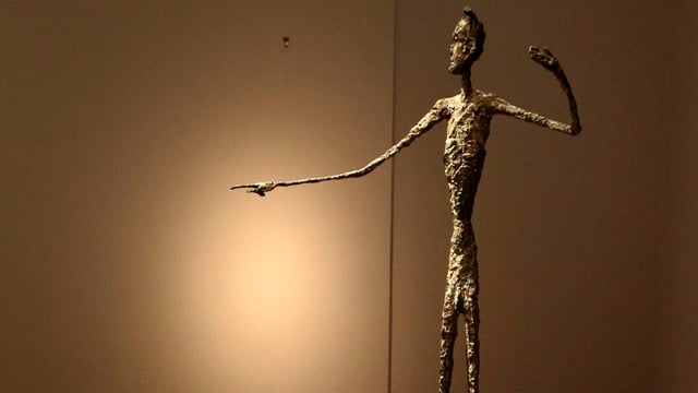Eine Bronzefigur in einem Museumsraum. 