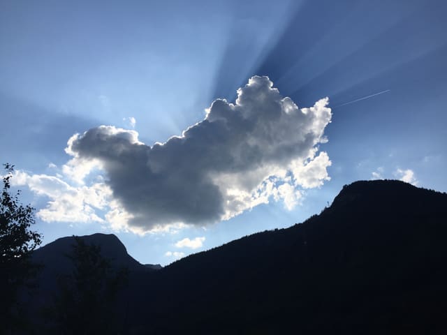 Eine kleine Quellwolke verdeckt die Sonne. In der dunstigen Luft zeichnen die Sonnenstrahlen perfekte Linien.