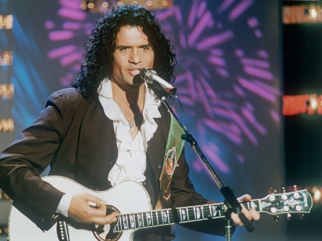 Ein Mann mit langen schwarzen Haaren und weisser Gitarre. Ein Mann mit langen schwarzen Haaren und weisser Gitarre.