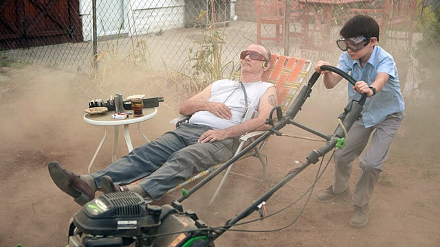 Bill Murray liegt im Liegestuhle, während der Junge Rasen mäht. Bill Murray liegt im Liegestuhle, während der Junge Rasen mäht.