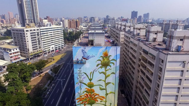 Eine komplette Hochhaus-Wand in einer Metropole ist mit Blumen bemalt. Eine komplette Hochhaus-Wand in einer Metropole ist mit Blumen bemalt.