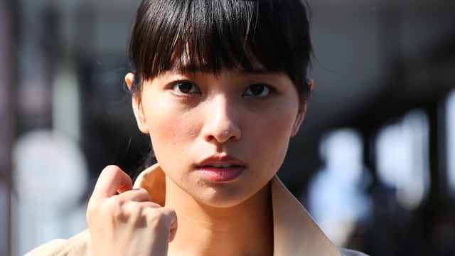 Nahaufnahme einer asiatisch aussehende Frau, die direkt in die Kamera blickt. Nahaufnahme einer asiatisch aussehende Frau, die direkt in die Kamera blickt.
