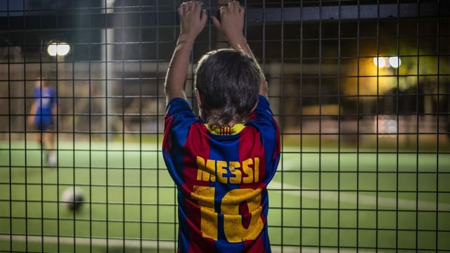 Kleiner Messi-Fan hinter einem Zaun Kleiner Messi-Fan hinter einem Zaun