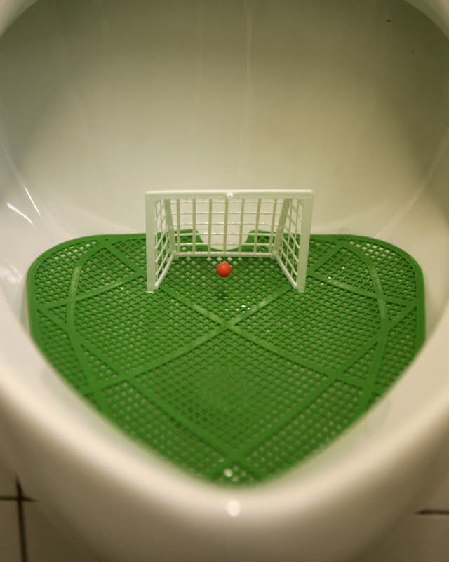 Ein Pissoir mit einem integrierten kleinen Fussballtor. Ein Pissoir mit einem integrierten kleinen Fussballtor.