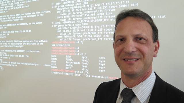 Er steht vor einer Wand mit Codes zur Abwehr von Cyber-Kriminellen. Er steht vor einer Wand mit Codes zur Abwehr von Cyber-Kriminellen.