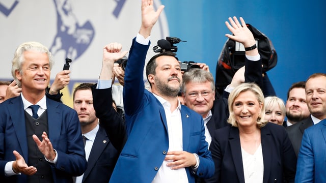 Salvini, Le Pen, Wilders und Co. stehen in einer Reihe und lachen und winken. Salvini, Le Pen, Wilders und Co. stehen in einer Reihe und lachen und winken.