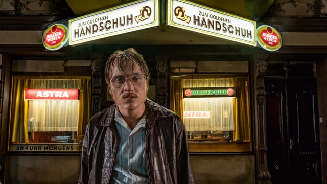 Ein versiffter Typ steht vor einer Spelunke. Ein versiffter Typ steht vor einer Spelunke.