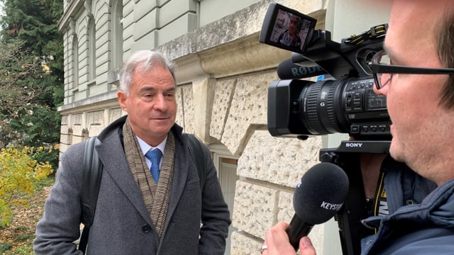 Mann mit Kamera rechts im Bild, anderer Mann links im Bild guckt Richtung Kamera. Mann mit Kamera rechts im Bild, anderer Mann links im Bild guckt Richtung Kamera.