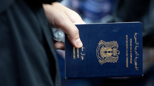 Eine Frau mit einem syrischen Pass in der Hand Eine Frau mit einem syrischen Pass in der Hand