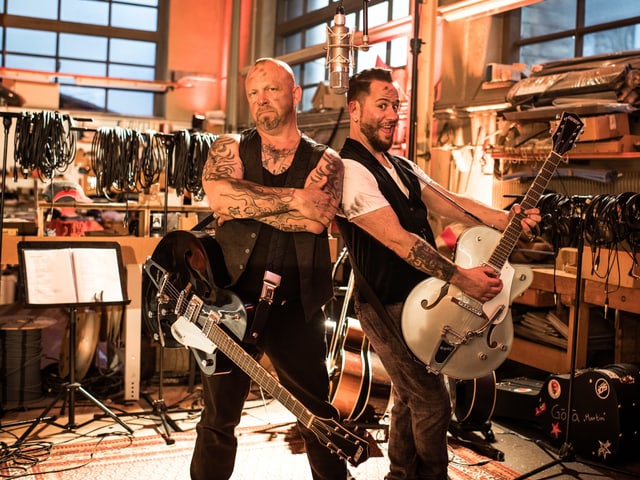 Göla und Marc Trauffer posieren mit ihren Gitarren. Göla und Marc Trauffer posieren mit ihren Gitarren.