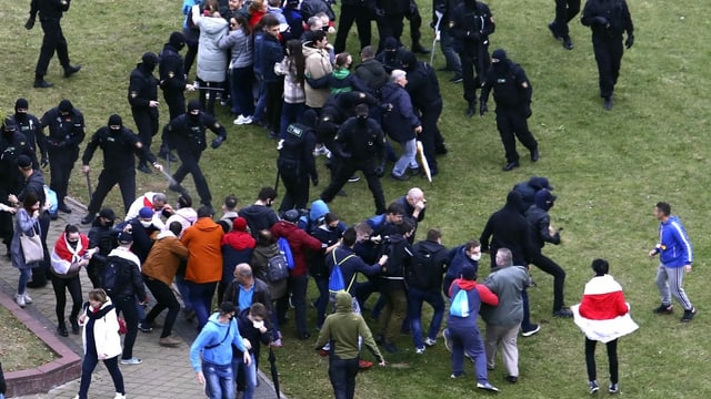 Uniformierte Polizisten prügeln auf Passanten ein. Uniformierte Polizisten prügeln auf Passanten ein.