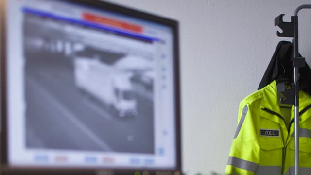 Büro mit PC-Bildschirm und gelber Schutzjacke am Kleiderständer. Büro mit PC-Bildschirm und gelber Schutzjacke am Kleiderständer.