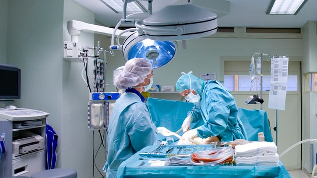 Operationssaal, in dem zwei Ärzte eine Operation durchführen.