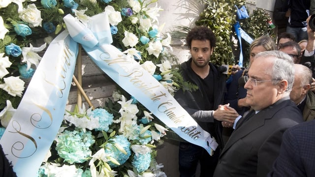 Lazio-Präsident Claudio Lotito hängt einen Kranz mit Lazio-Farben an einer Synagoge auf. Lazio-Präsident Claudio Lotito hängt einen Kranz mit Lazio-Farben an einer Synagoge auf.