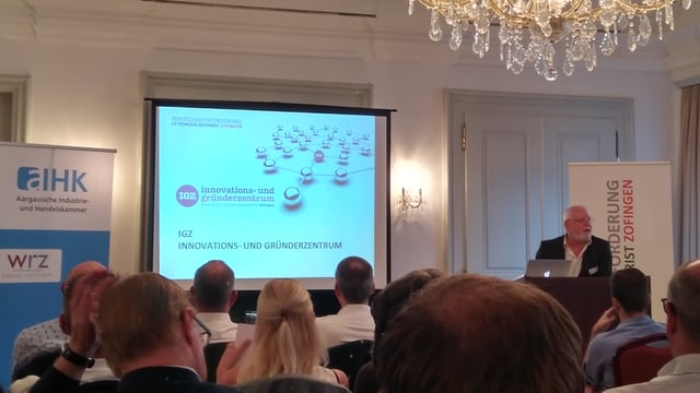 Ein Mann spricht vor einem Publikum Ein Mann spricht vor einem Publikum