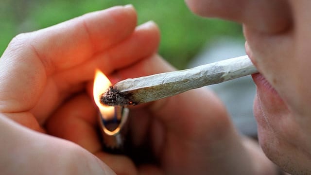 Ein Mann zündet einen Joint an Ein Mann zündet einen Joint an