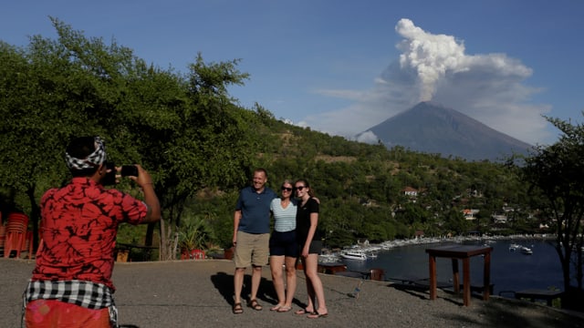 Touristen posieren vor Vulkan. Guide schiesst ein Foto. Touristen posieren vor Vulkan. Guide schiesst ein Foto.