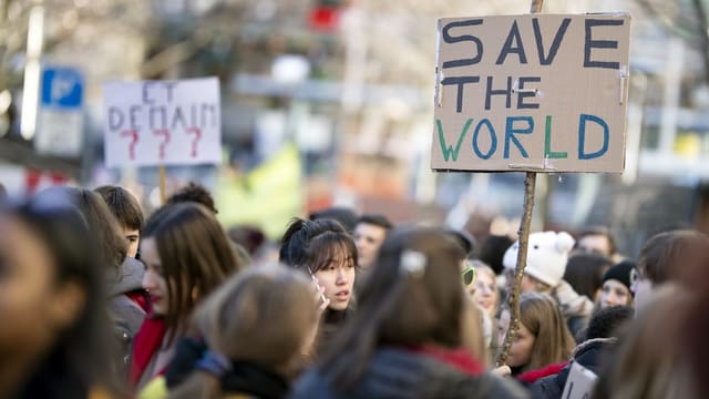 Gruppe von Jugendlichen. Auf einem Plakat steht: Save the World. Gruppe von Jugendlichen. Auf einem Plakat steht: Save the World.