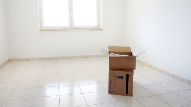 Eine leerer Wohnraum – bis auf zwei Kartonschachteln. Eine leerer Wohnraum – bis auf zwei Kartonschachteln.