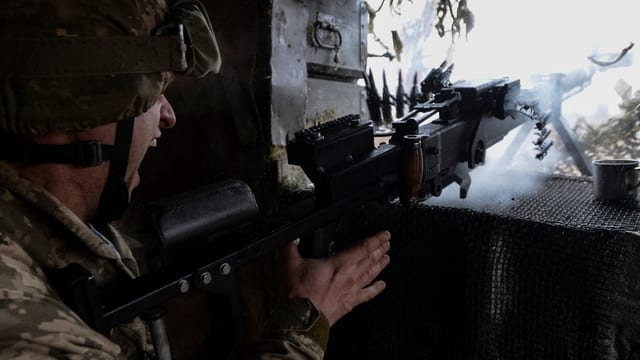Ein ukranischer Soldat feuert mit seinem Maschinengewehr: Ein ukranischer Soldat feuert mit seinem Maschinengewehr: