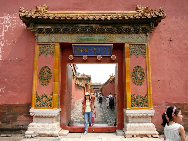 Besucher passieren ein farbig verziertes Tor zu Verbotenen Stadt in Peking. Besucher passieren ein farbig verziertes Tor zu Verbotenen Stadt in Peking.
